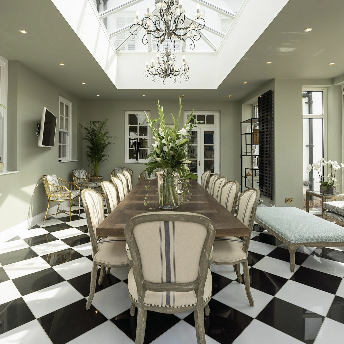 A grand formal dining room with a black and white checkered floor, chandelier and classical styling - Atlantic Interiors installation and styling