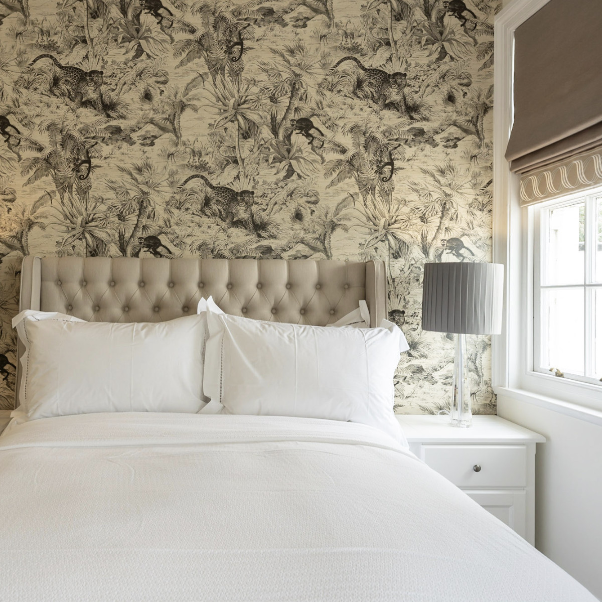 A luxury residential bedroom interior designed by Atlantic Interiors - botanical wallpaper and tufted headboard